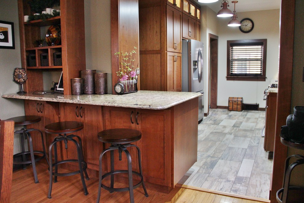 Enclosed kitchen - mid-sized transitional galley ceramic tile enclosed kitchen idea with an undermount sink, shaker cabinets, medium tone wood cabinets, quartz countertops, beige backsplash, stone tile backsplash, stainless steel appliances and a peninsula