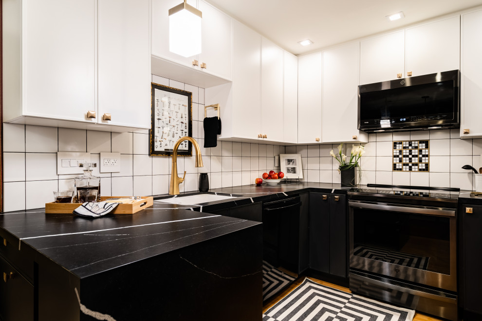 Modern inredning av ett litet svart svart kök, med en undermonterad diskho, skåp i shakerstil, svarta skåp, bänkskiva i kvarts, vitt stänkskydd, stänkskydd i keramik, rostfria vitvaror, brunt golv, mellanmörkt trägolv och en halv köksö