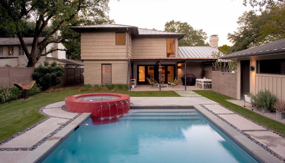 Mid-sized contemporary backyard rectangular lap pool in Dallas with concrete slab and a hot tub.