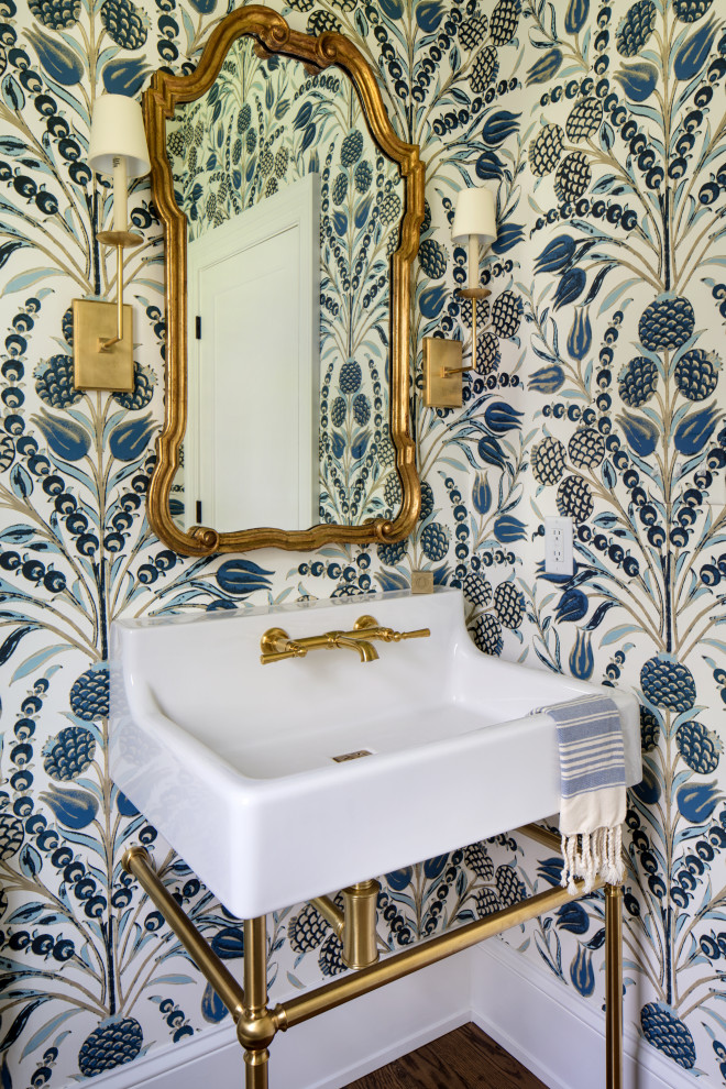 This is an example of a small beach style powder room in Richmond with an urinal, blue walls, medium hardwood floors, a pedestal sink, brown floor and white benchtops.