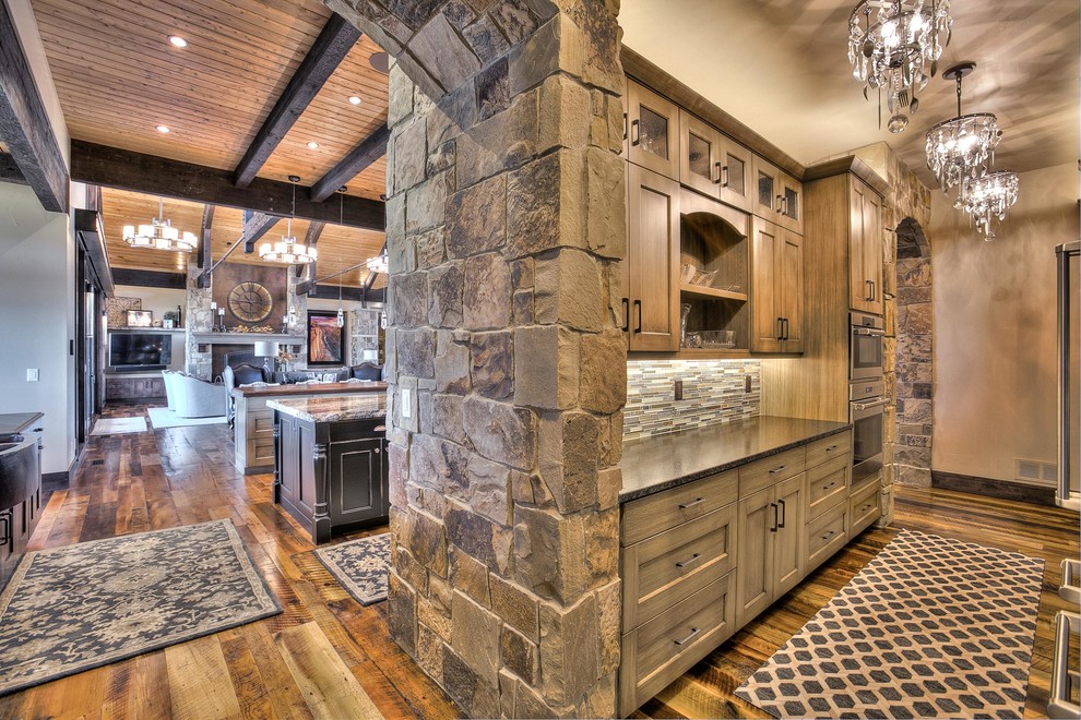 Eat-in kitchen - huge rustic l-shaped medium tone wood floor eat-in kitchen idea in Denver with an undermount sink, shaker cabinets, medium tone wood cabinets, granite countertops, beige backsplash, stone tile backsplash, stainless steel appliances and two islands