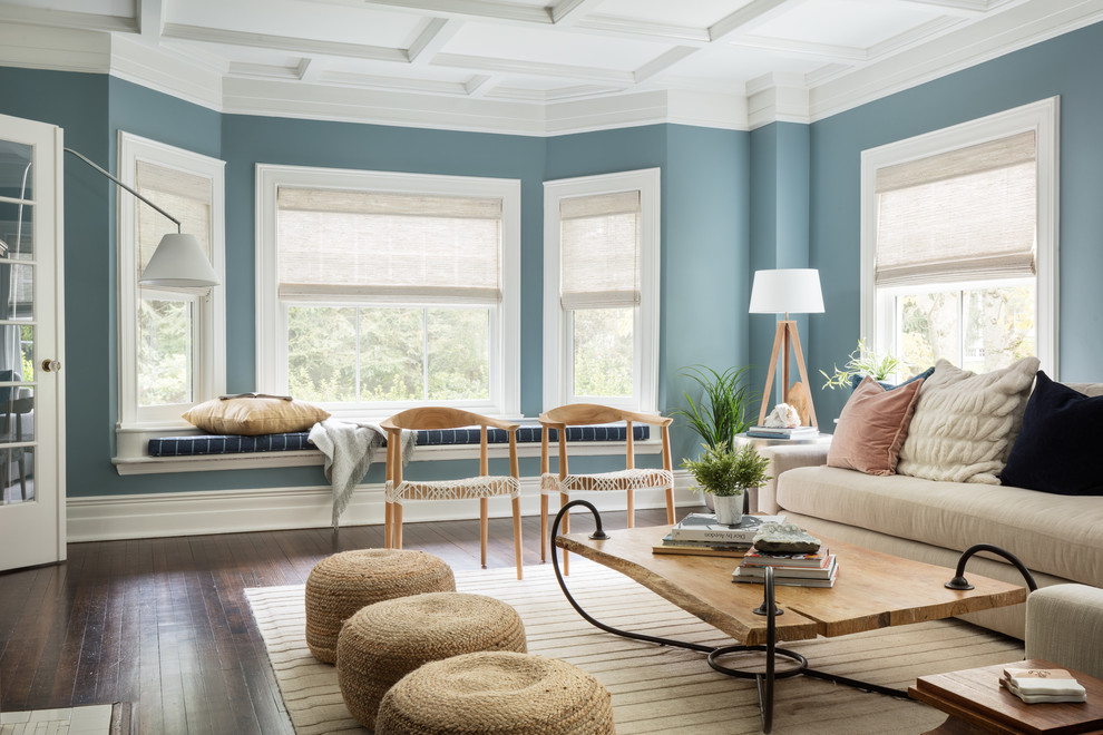 Photo of a large beach style living room in New York with blue walls, dark hardwood floors and brown floor.