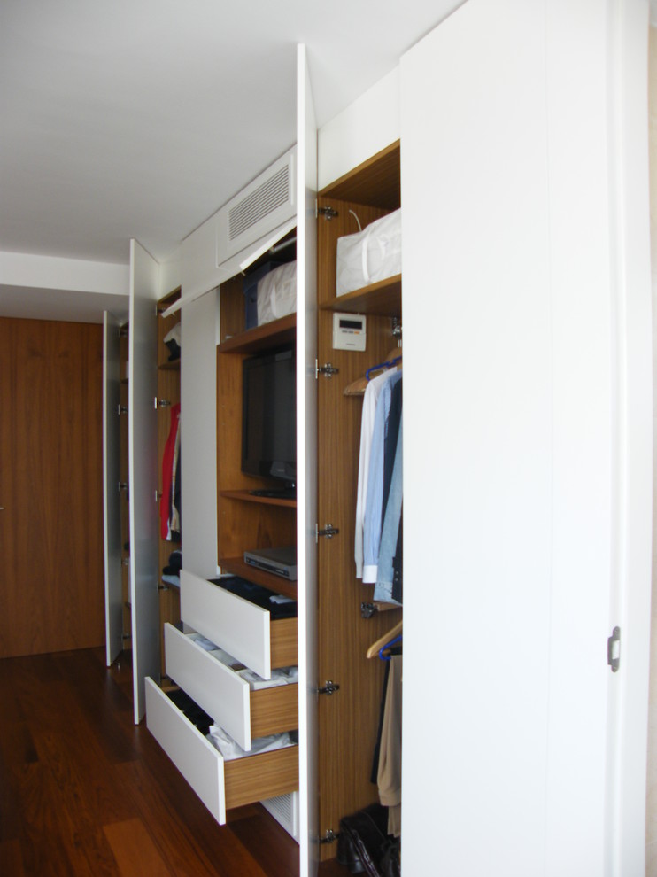 Diseño de armario unisex tradicional renovado de tamaño medio con armarios con paneles lisos, puertas de armario blancas y suelo de madera en tonos medios