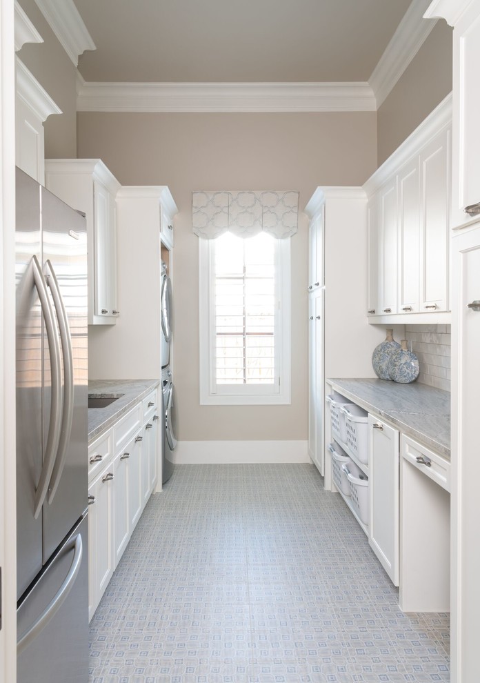 Inspiration for a transitional galley utility room in Dallas with an undermount sink, recessed-panel cabinets, white cabinets and a stacked washer and dryer.