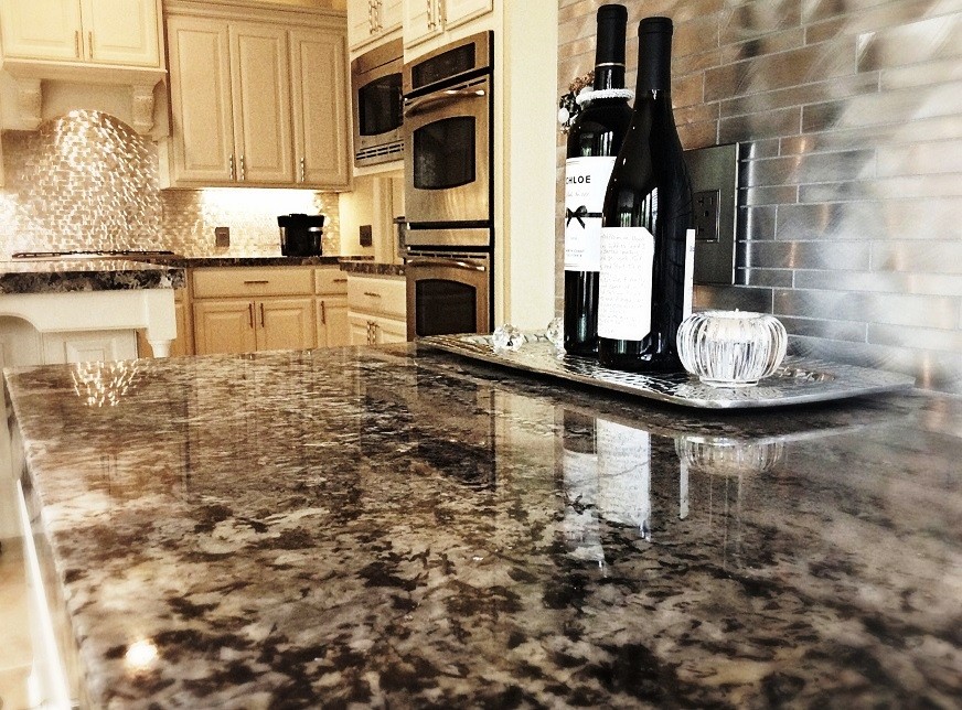 Inspiration for a mid-sized transitional l-shaped travertine floor eat-in kitchen remodel in Houston with a farmhouse sink, raised-panel cabinets, white cabinets, granite countertops, metallic backsplash, metal backsplash, stainless steel appliances and an island