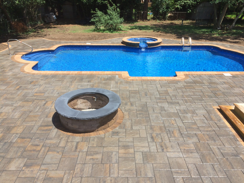 Inspiration for a large transitional backyard concrete paver and custom-shaped hot tub remodel