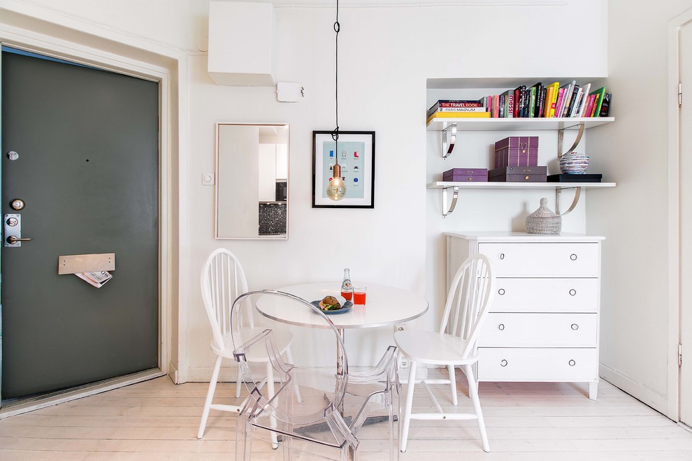 This is an example of a small scandinavian dining room in Stockholm with white walls, light hardwood floors and no fireplace.