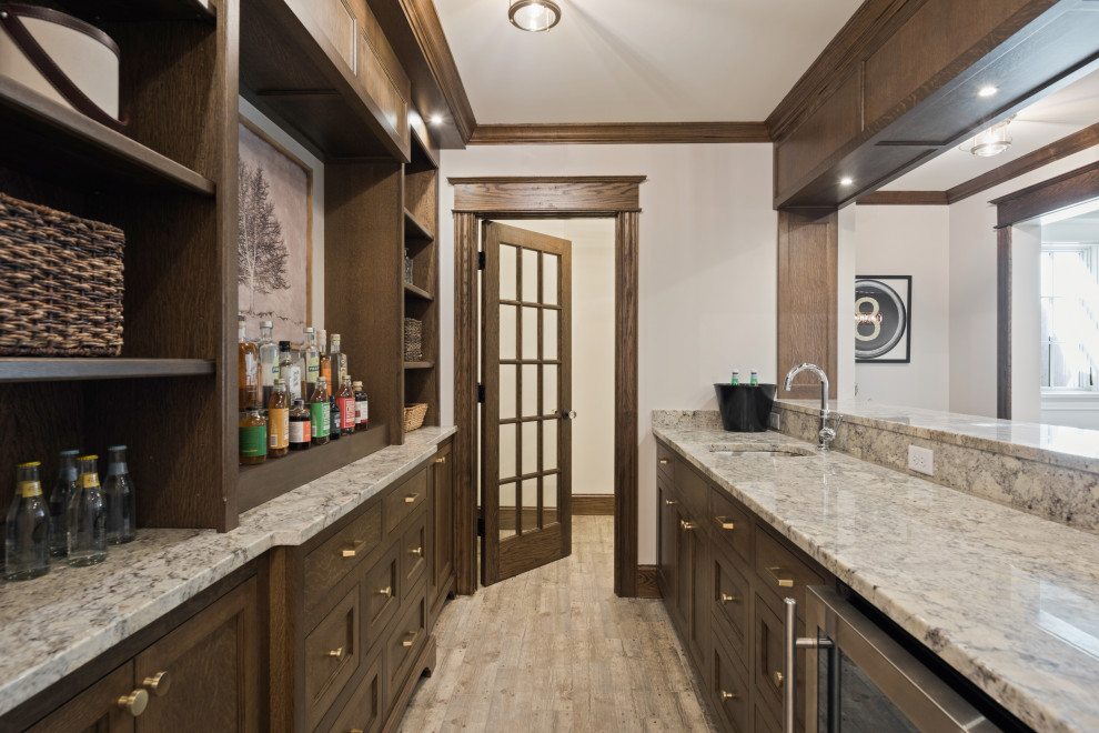 Photo of a beach style wet bar in Minneapolis with an undermount sink, dark wood cabinets and multi-coloured benchtop.