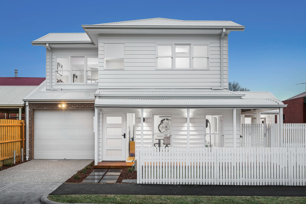 Design ideas for a small contemporary two-storey white townhouse exterior in Melbourne with wood siding, a gable roof and a metal roof.