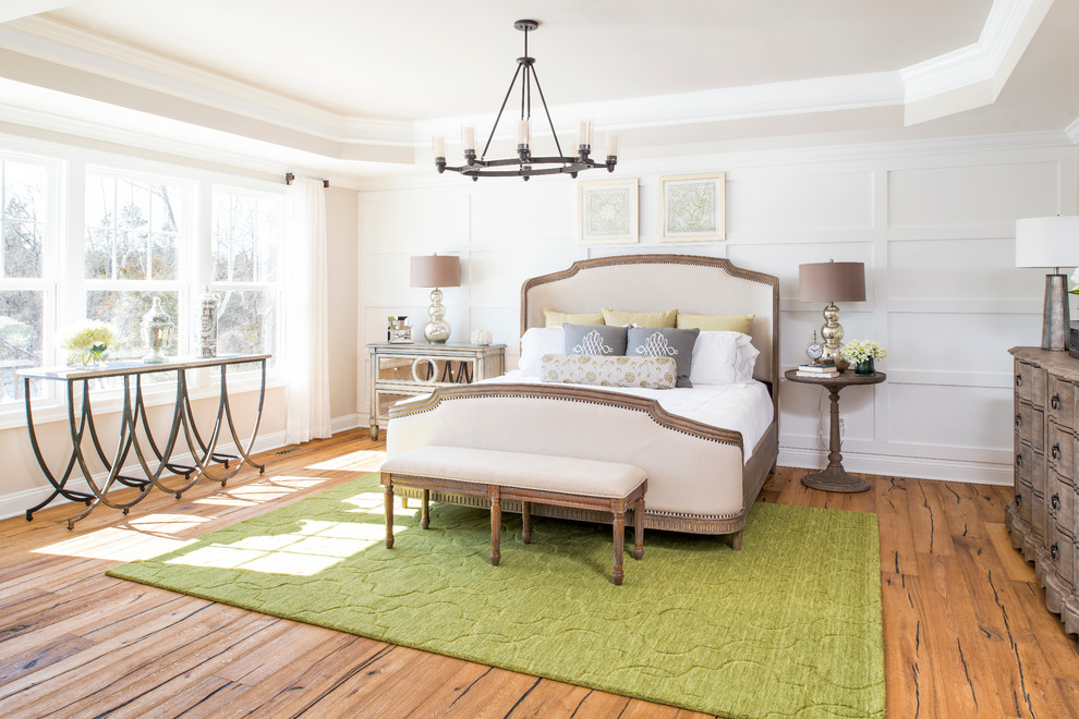 This is an example of a traditional master bedroom in DC Metro with white walls and medium hardwood floors.