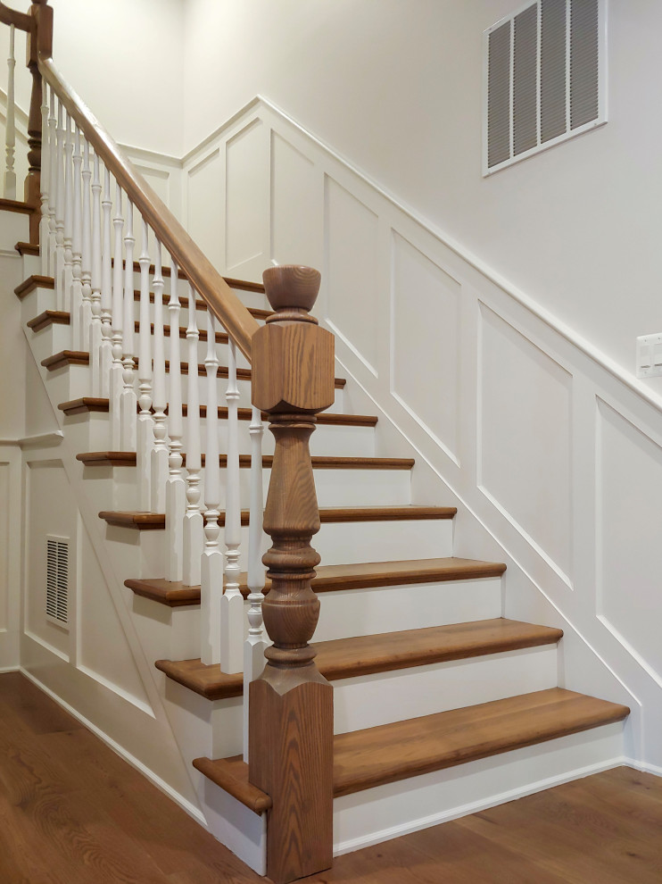 Ejemplo de escalera en U tradicional de tamaño medio con escalones de madera, contrahuellas de madera pintada, barandilla de madera y boiserie