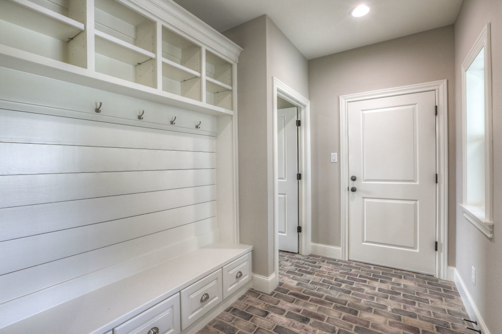 Design ideas for a mid-sized transitional mudroom in Houston with beige walls, a single front door, brick floors, a white front door and beige floor.