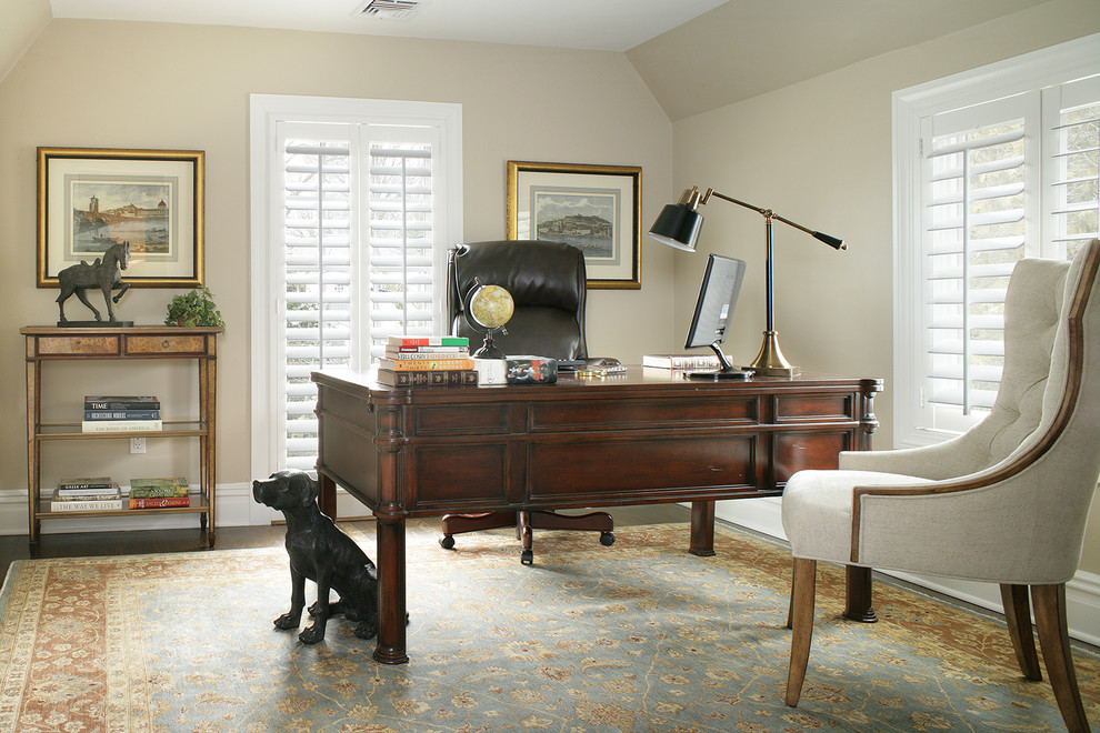 This is an example of a traditional home office in New York with beige walls and a freestanding desk.
