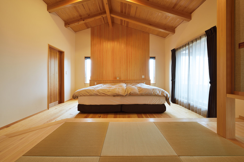 This is an example of an asian bedroom in Other with white walls, light hardwood floors and beige floor.