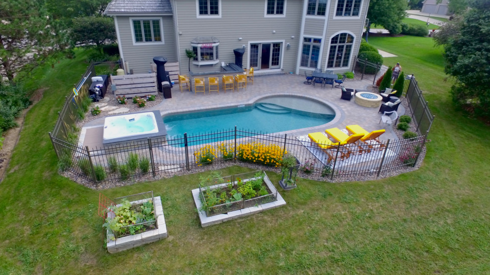 Foto di una piccola piscina boho chic personalizzata dietro casa con una vasca idromassaggio e pavimentazioni in cemento