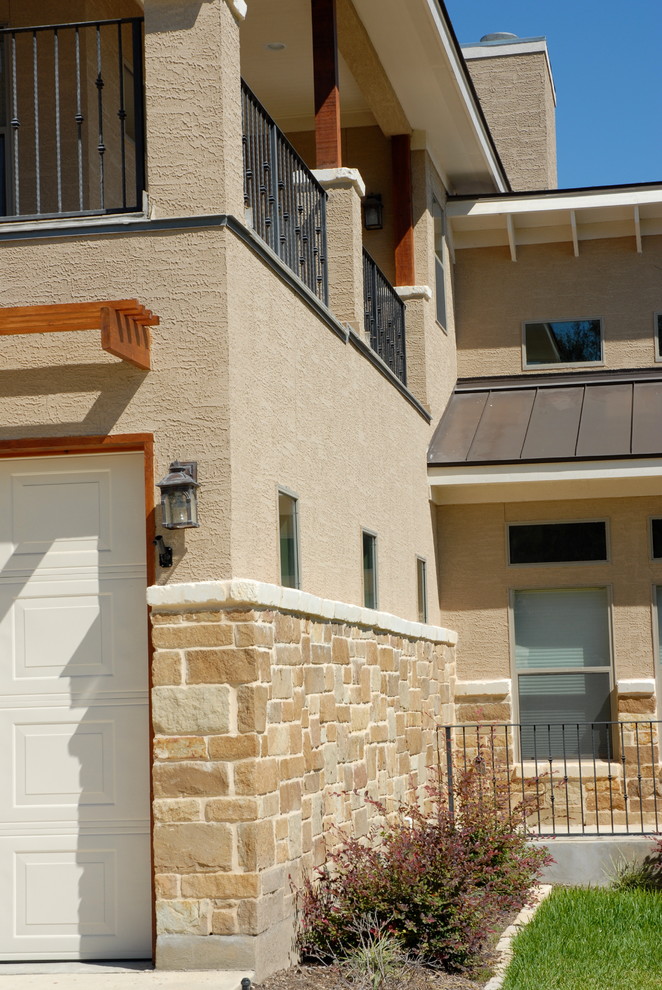 This is an example of a mid-sized traditional two-storey stucco beige exterior in Austin with a gable roof.