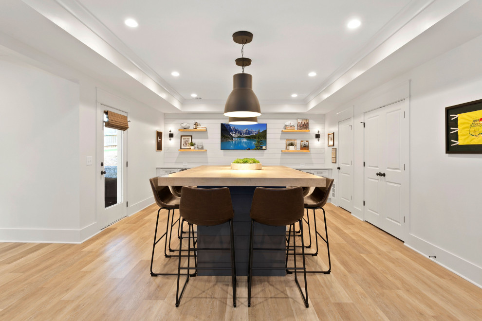 Inspiration for a mid-sized contemporary walk-out laminate floor, beige floor, tray ceiling and shiplap wall basement remodel in Atlanta with a bar, white walls and no fireplace
