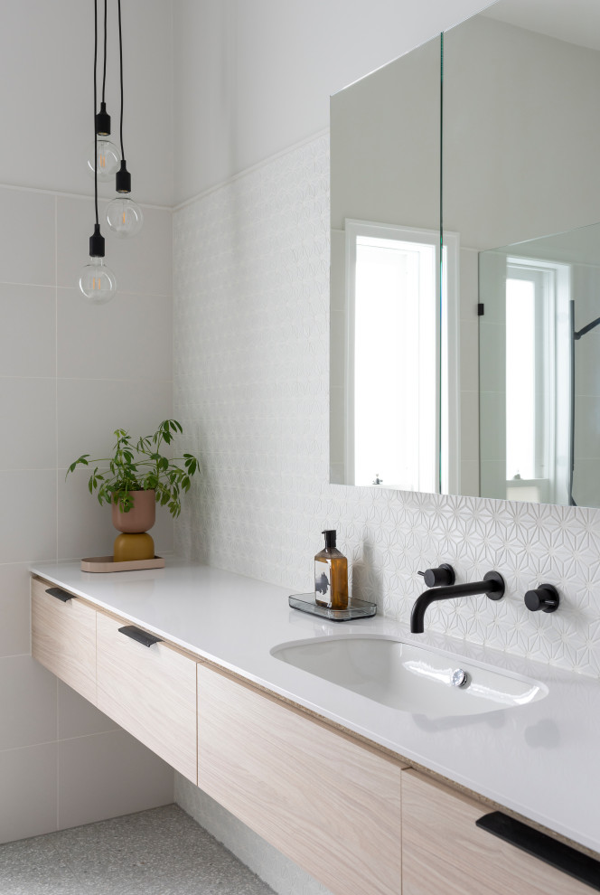 This is an example of a large contemporary master bathroom in Melbourne with flat-panel cabinets, white tile, mosaic tile, white walls, ceramic floors, grey floor, a floating vanity, light wood cabinets, an undermount sink and white benchtops.