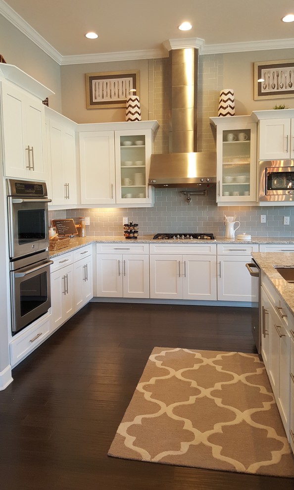Inspiration for a traditional u-shaped open plan kitchen in Miami with an undermount sink, shaker cabinets, white cabinets, granite benchtops, grey splashback, ceramic splashback, stainless steel appliances, dark hardwood floors and with island.