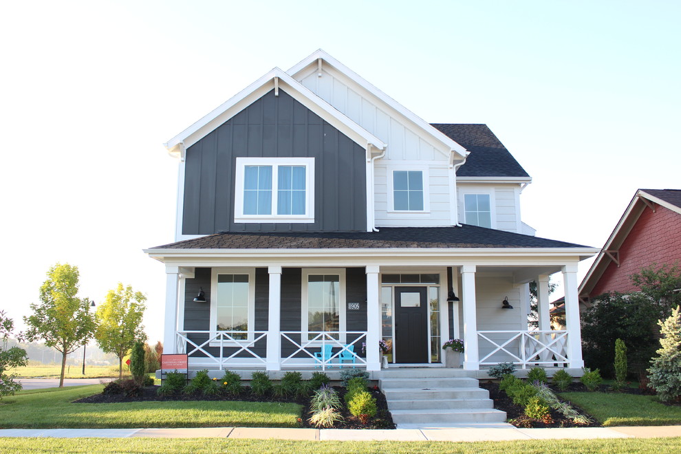 Photo of a large country two-storey grey house exterior in Kansas City with vinyl siding, a gable roof and a tile roof.