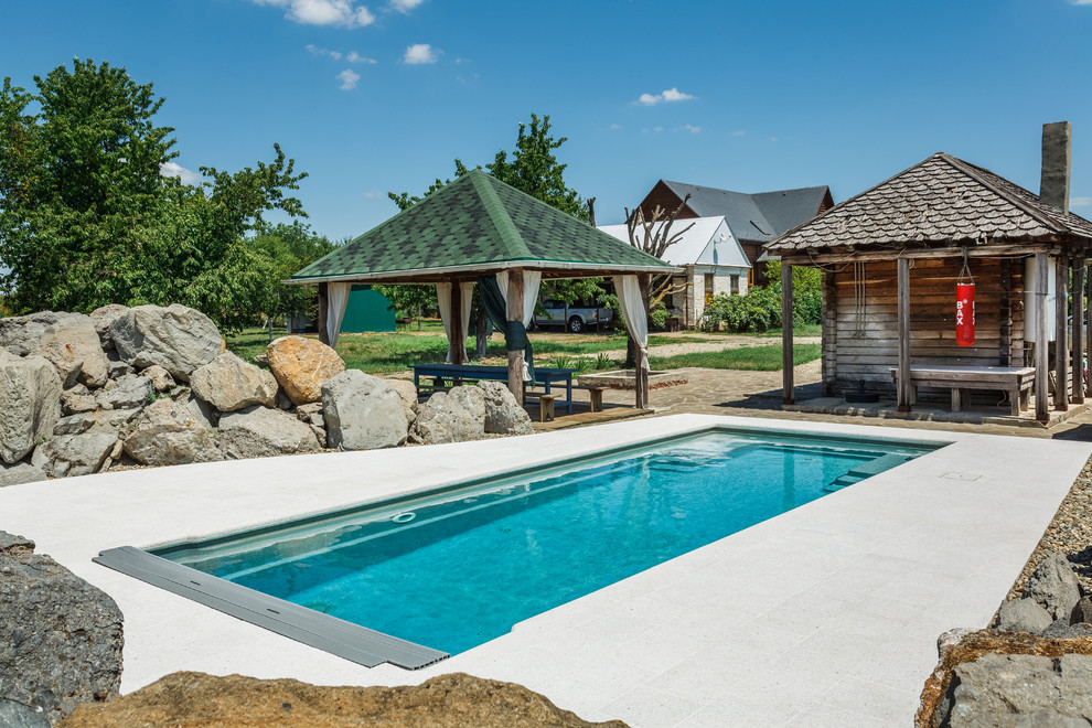 This is an example of a country backyard rectangular pool in Other.
