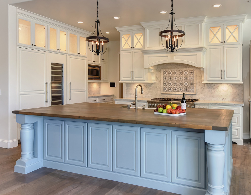 Inspiration for a traditional kitchen in Sacramento with raised-panel cabinets, beige cabinets, wood benchtops, multi-coloured splashback, panelled appliances, dark hardwood floors, with island and brown floor.