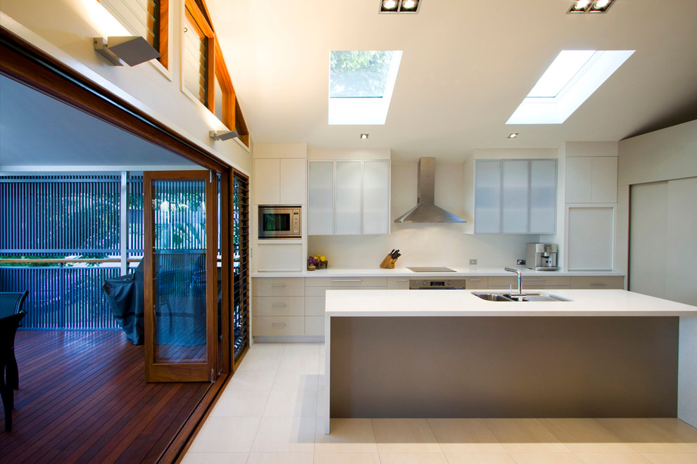 Inspiration for a mid-sized modern galley eat-in kitchen in Brisbane with a double-bowl sink, flat-panel cabinets, beige cabinets, beige splashback, stainless steel appliances, with island and beige floor.