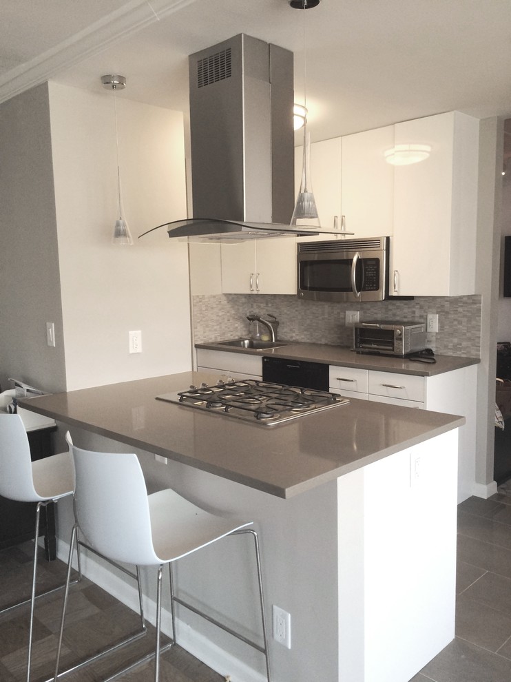 This is an example of a small contemporary kitchen in New York with flat-panel cabinets, engineered stone countertops, mosaic tiled splashback and an island.