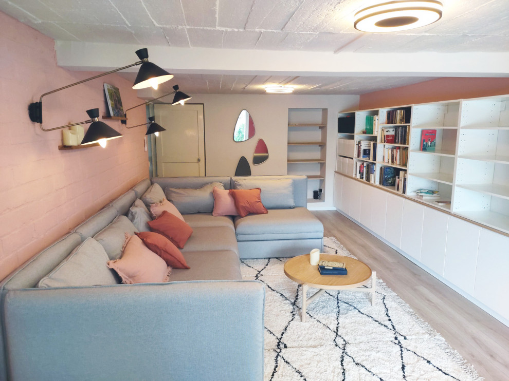 Idéer för att renovera en mellanstor funkis källare ovan mark, med rosa väggar och laminatgolv