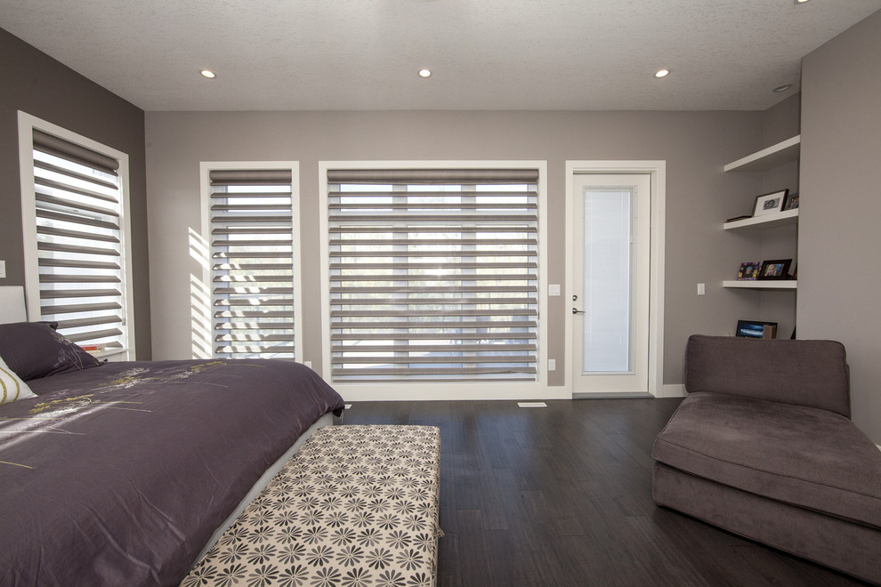 Inspiration for a large transitional master bedroom in Edmonton with grey walls, dark hardwood floors and a tile fireplace surround.