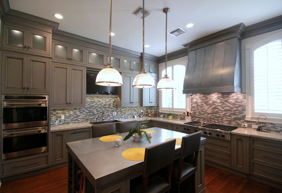 Enclosed kitchen - large transitional l-shaped dark wood floor and brown floor enclosed kitchen idea in Miami with a farmhouse sink, recessed-panel cabinets, gray cabinets, granite countertops, multicolored backsplash, mosaic tile backsplash, stainless steel appliances and an island