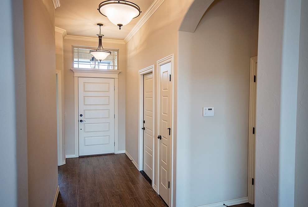 Photo of a mid-sized transitional entry hall in Oklahoma City with beige walls, medium hardwood floors, a single front door, a white front door and red floor.