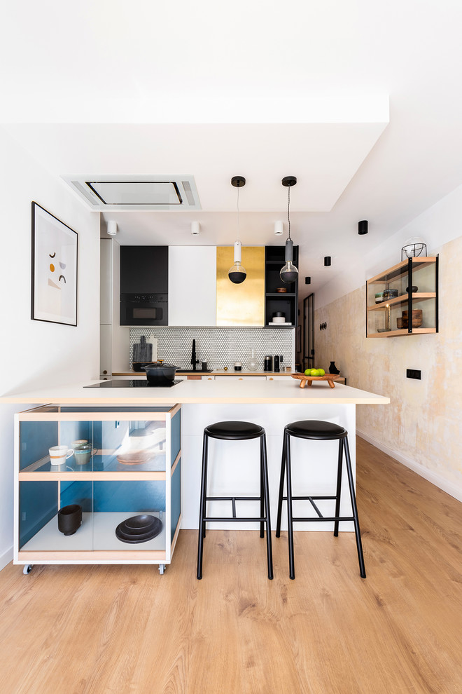 Mid-sized contemporary galley kitchen in Other with a drop-in sink, flat-panel cabinets, white cabinets, white splashback, mosaic tile splashback, medium hardwood floors, a peninsula, brown floor and white benchtop.