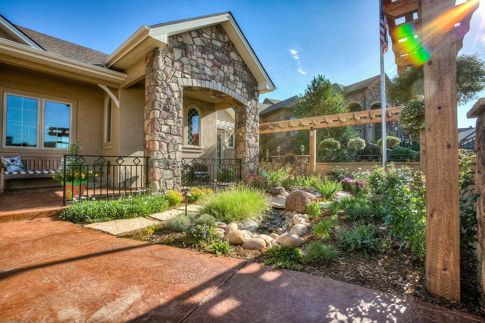 Photo of a mid-sized transitional partial sun front yard stone walkway in Denver.