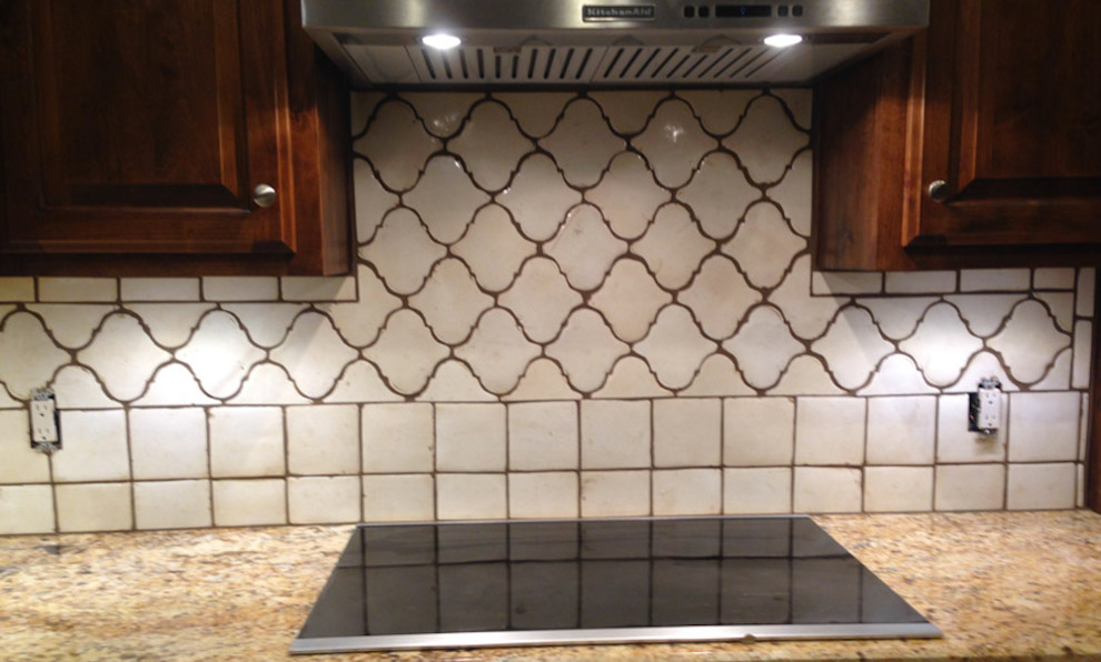 Inspiration for a mid-sized transitional l-shaped enclosed kitchen remodel in Austin with an island, raised-panel cabinets, dark wood cabinets, granite countertops, white backsplash, ceramic backsplash and stainless steel appliances