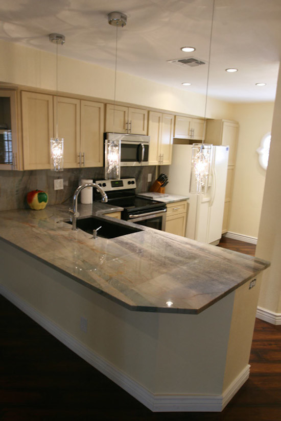 Example of a mid-sized transitional l-shaped dark wood floor and brown floor enclosed kitchen design in Phoenix with an undermount sink, shaker cabinets, light wood cabinets, granite countertops, beige backsplash, stone slab backsplash, stainless steel appliances and a peninsula