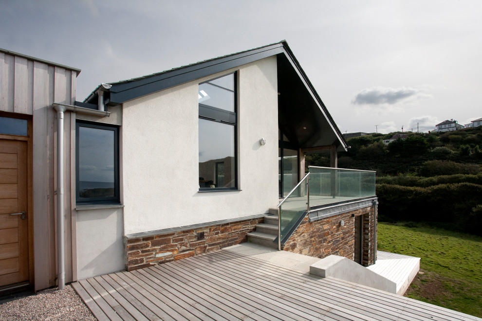 This is an example of a medium sized nautical back ground level glass railing terrace in Cornwall with no cover.