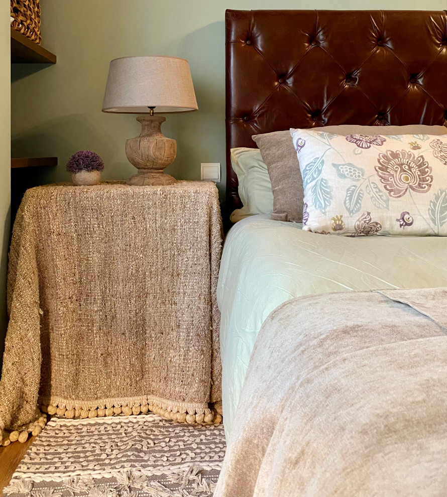 Ejemplo de dormitorio principal tradicional renovado con paredes verdes, suelo de madera en tonos medios, suelo marrón y vigas vistas