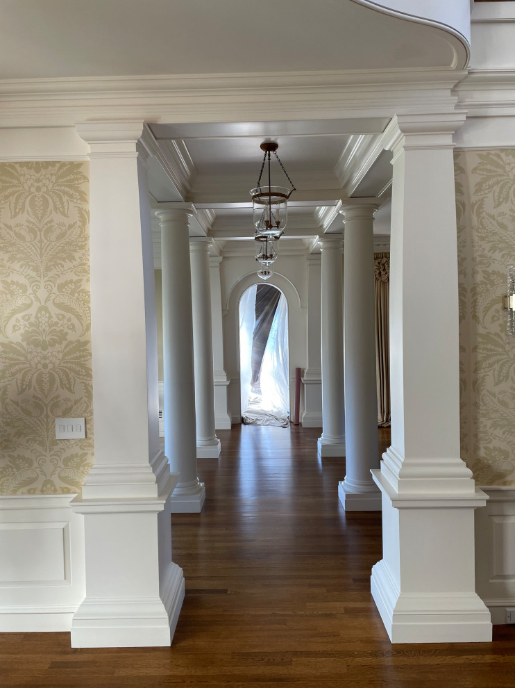 Foto di un ingresso o corridoio classico di medie dimensioni con pareti beige, pavimento in legno massello medio, pavimento marrone, carta da parati e soffitto a cassettoni