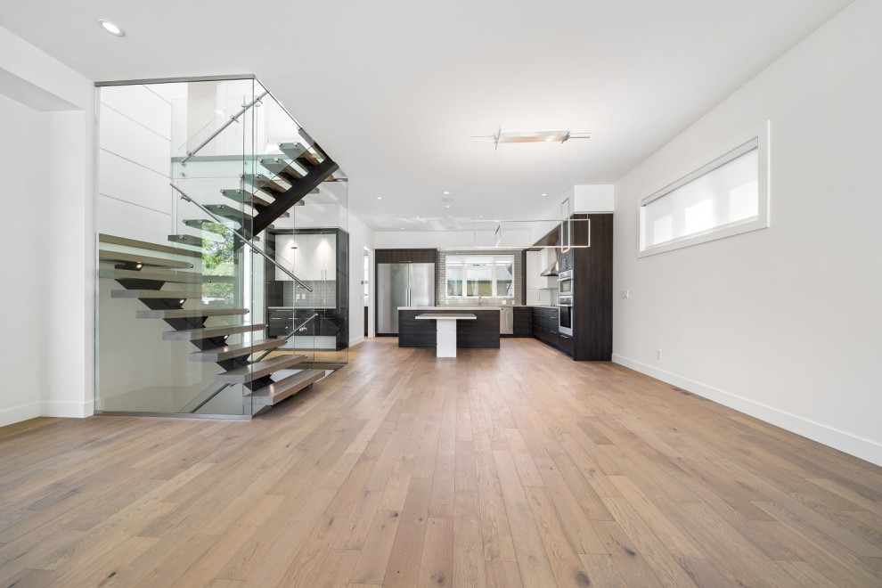 Inspiration for a mid-sized transitional l-shaped light wood floor and brown floor eat-in kitchen remodel in Calgary with an undermount sink, shaker cabinets, dark wood cabinets, quartzite countertops, gray backsplash, ceramic backsplash, stainless steel appliances, an island and beige countertops