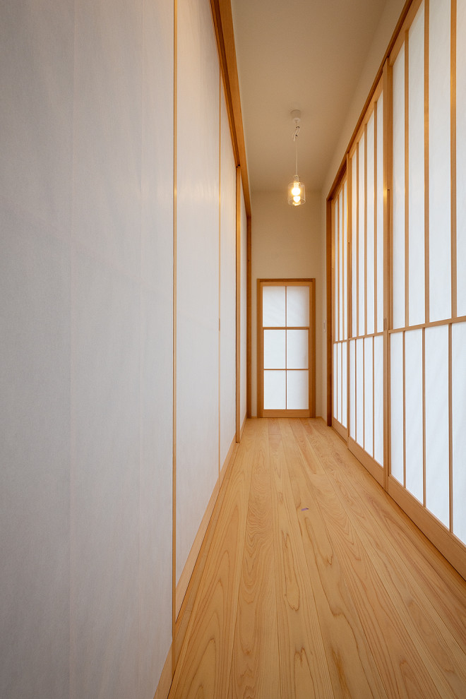 Inspiration för en liten hall, med vita väggar, ljust trägolv och beiget golv