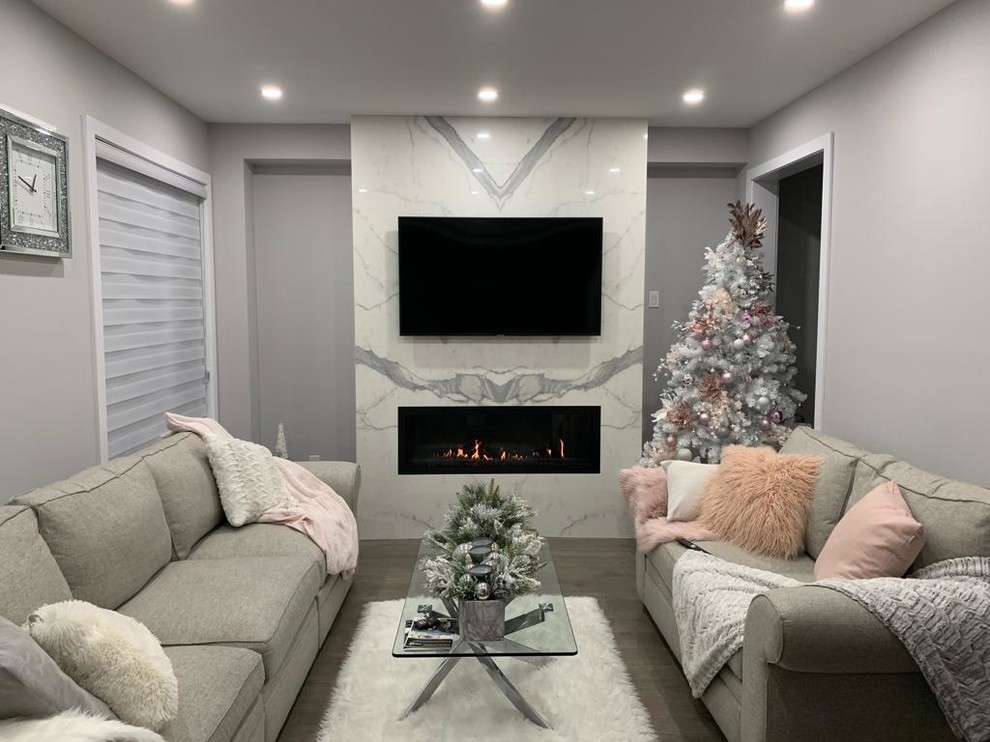 Photo of a modern living room in Toronto with grey walls, medium hardwood floors, a standard fireplace, a tile fireplace surround and turquoise floor.