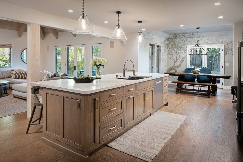Open concept kitchen - huge transitional l-shaped medium tone wood floor and brown floor open concept kitchen idea with an undermount sink, shaker cabinets, gray cabinets, quartz countertops, white backsplash, quartz backsplash, stainless steel appliances, an island and white countertops
