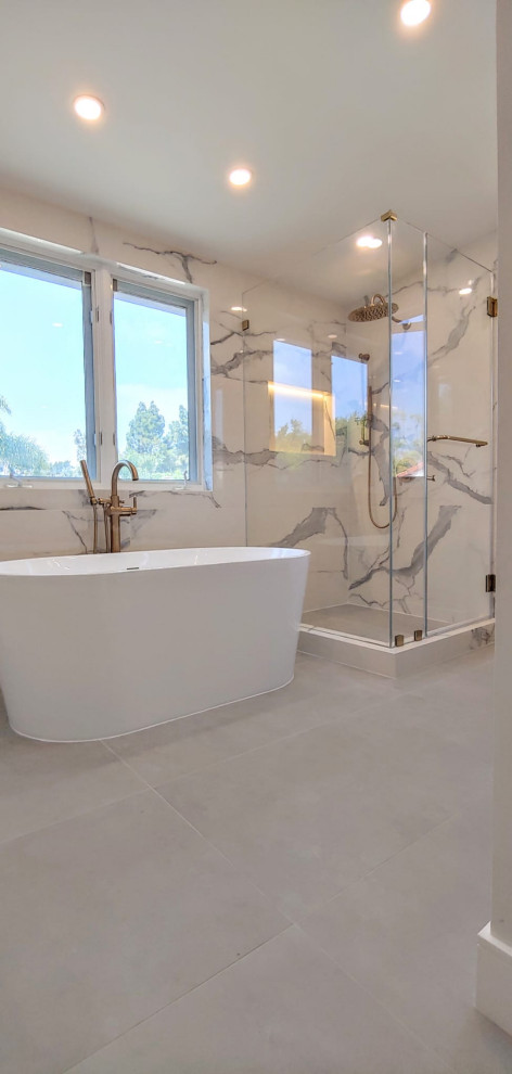 Inredning av ett modernt mellanstort en-suite badrum, med ett fristående badkar, en hörndusch, vit kakel, porslinskakel, vita väggar, klinkergolv i porslin och grått golv