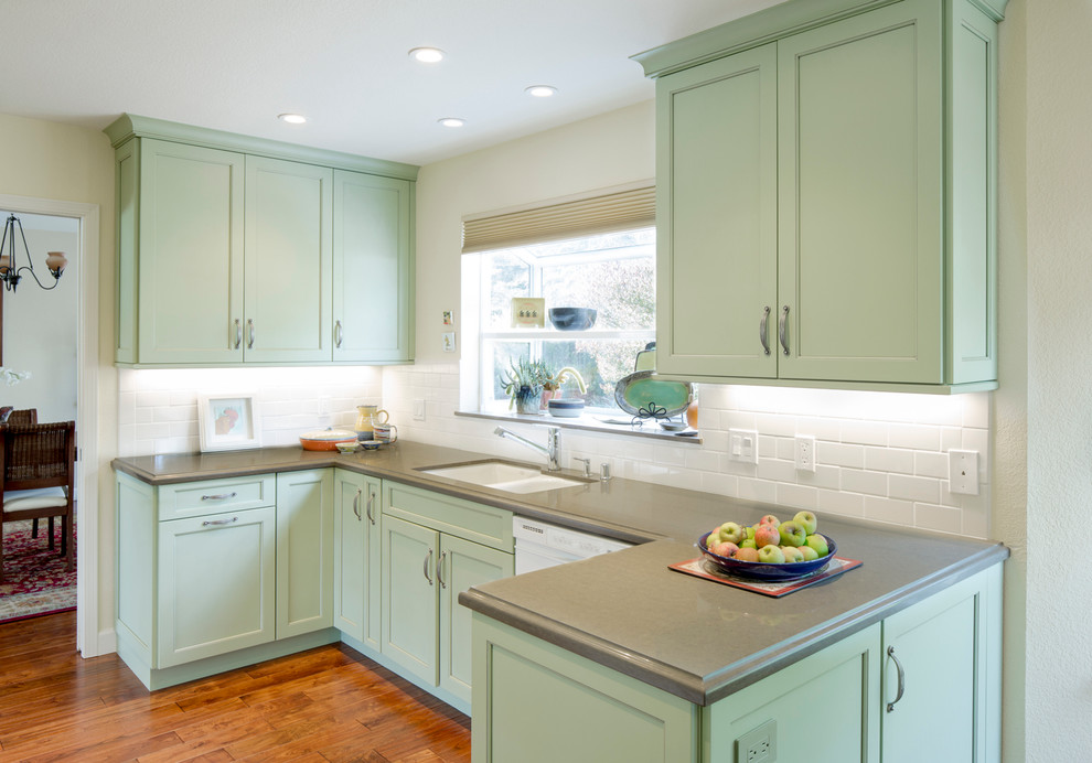 Photo of a traditional kitchen in San Francisco with an undermount sink, recessed-panel cabinets, green cabinets, white splashback, subway tile splashback and white appliances.