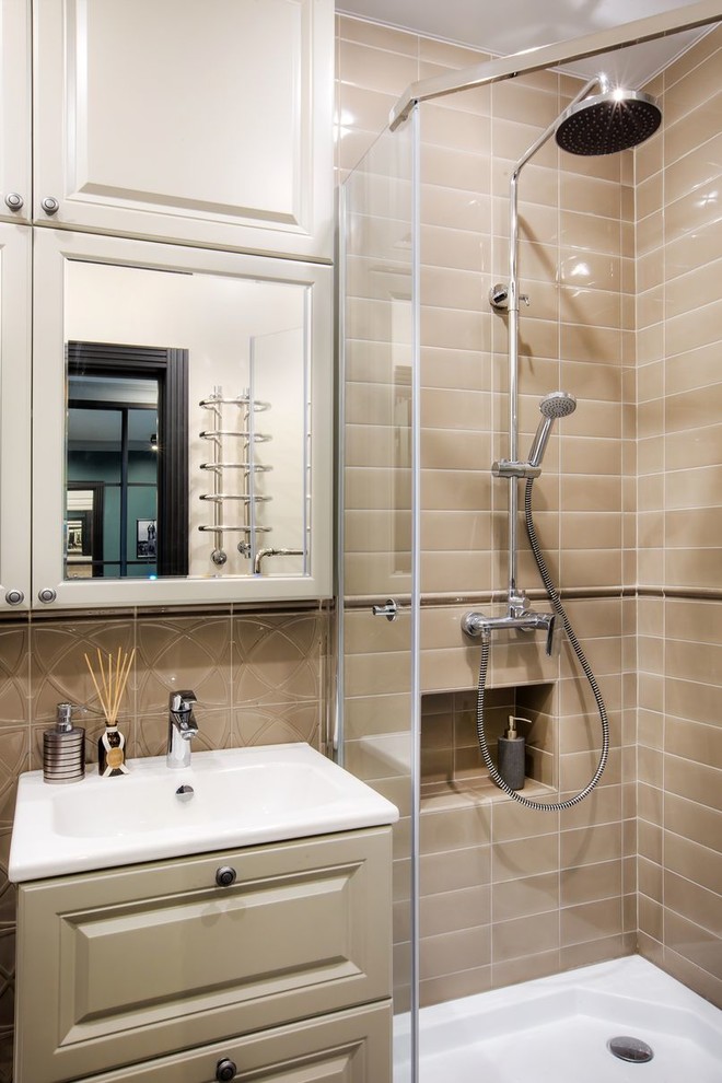 Inspiration for a small transitional 3/4 bathroom in Other with raised-panel cabinets, beige cabinets, a corner shower, a hinged shower door, a one-piece toilet, gray tile, ceramic tile, grey walls, porcelain floors and a wall-mount sink.