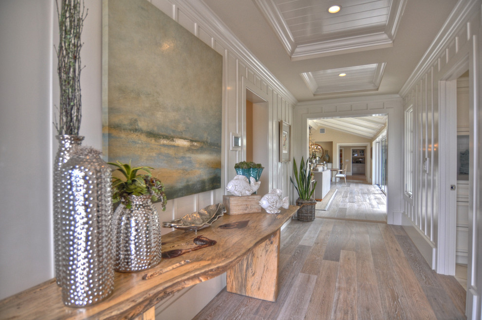 Inspiration for a beach style hallway in Los Angeles with white walls and medium hardwood floors.
