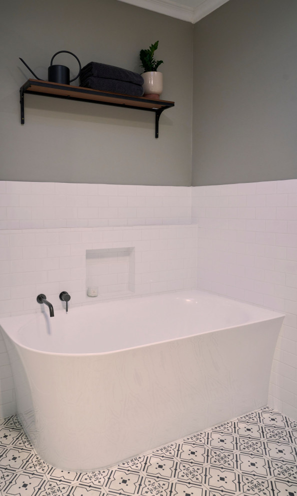 Cette image montre une salle de bain design de taille moyenne avec un placard avec porte à panneau encastré, des portes de placard blanches, une baignoire d'angle, une douche d'angle, WC à poser, un carrelage blanc, des carreaux de céramique, un mur marron, sol en béton ciré, une vasque, un plan de toilette en quartz modifié, un sol noir, une cabine de douche à porte battante, un plan de toilette blanc, buanderie, meuble simple vasque et meuble-lavabo encastré.