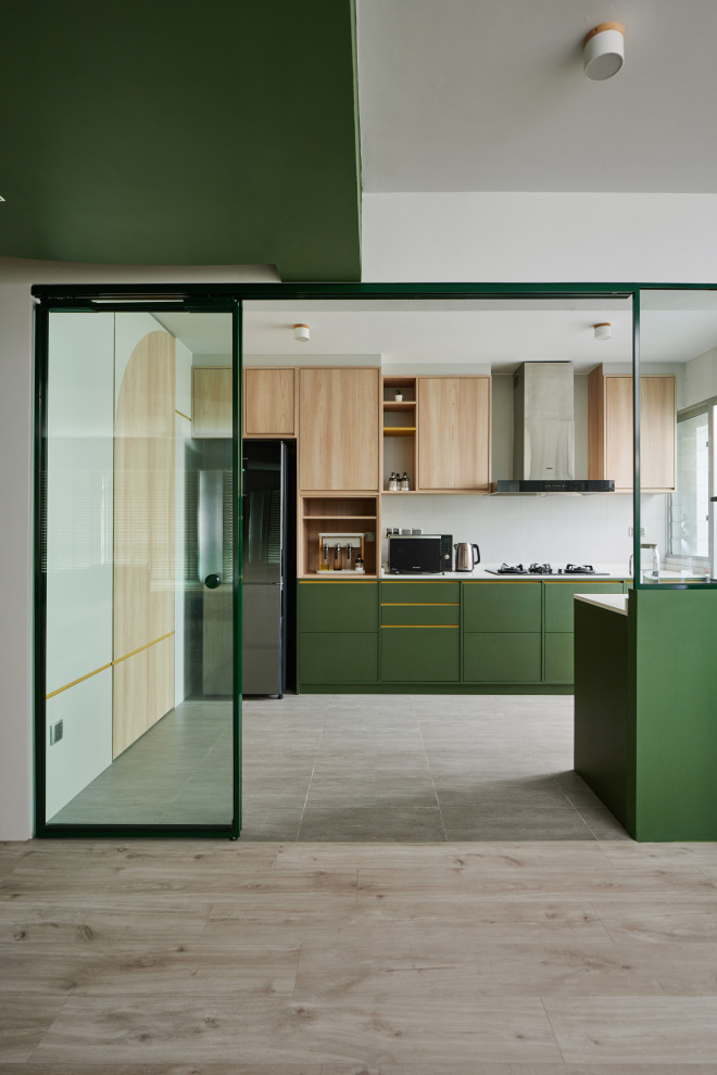 Design ideas for a contemporary galley kitchen in Singapore with flat-panel cabinets, green cabinets, white splashback, stainless steel appliances, light hardwood floors, a peninsula, beige floor and white benchtop.