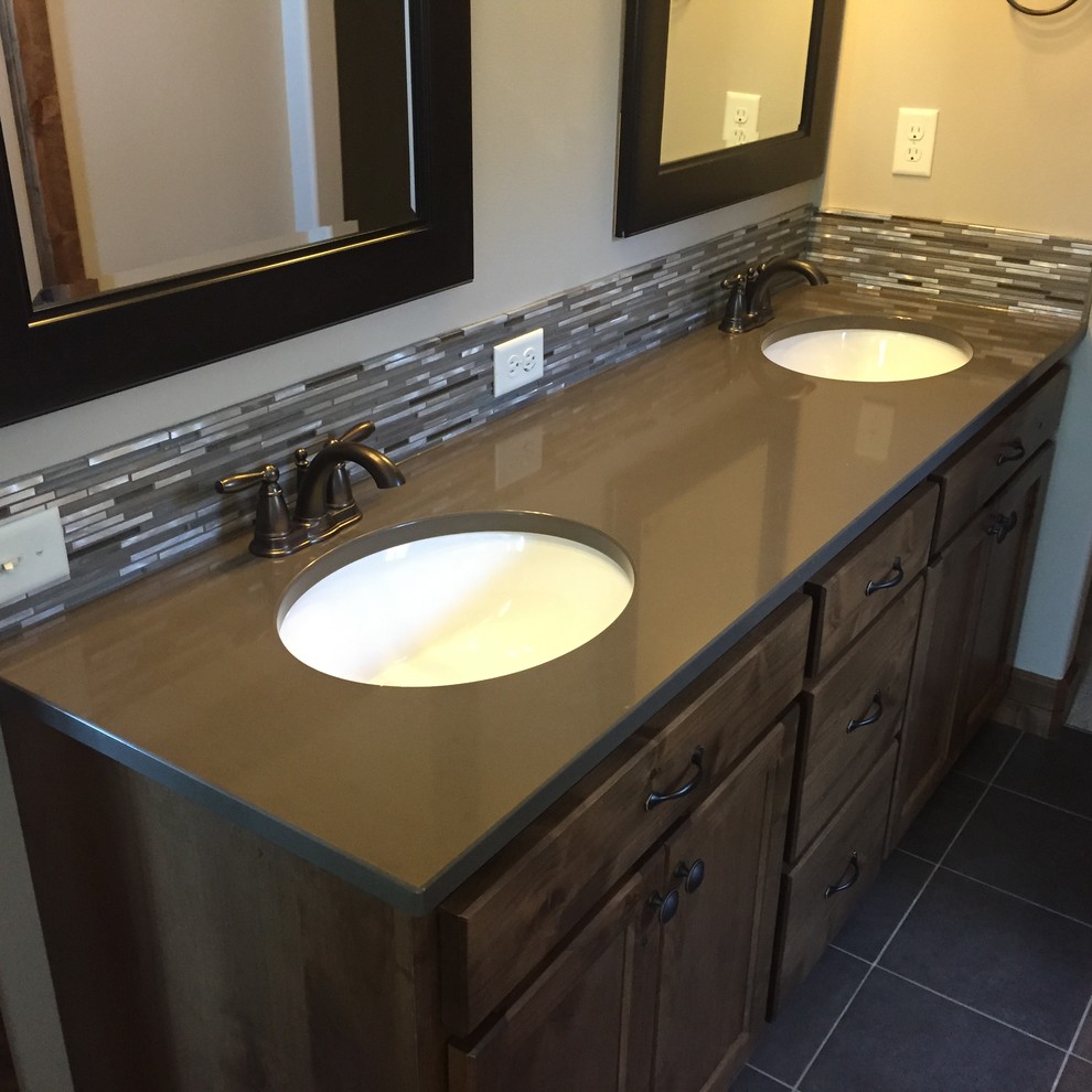 Design ideas for a mid-sized contemporary master bathroom in Seattle with an undermount sink, recessed-panel cabinets, brown cabinets, solid surface benchtops, gray tile, mosaic tile and beige walls.